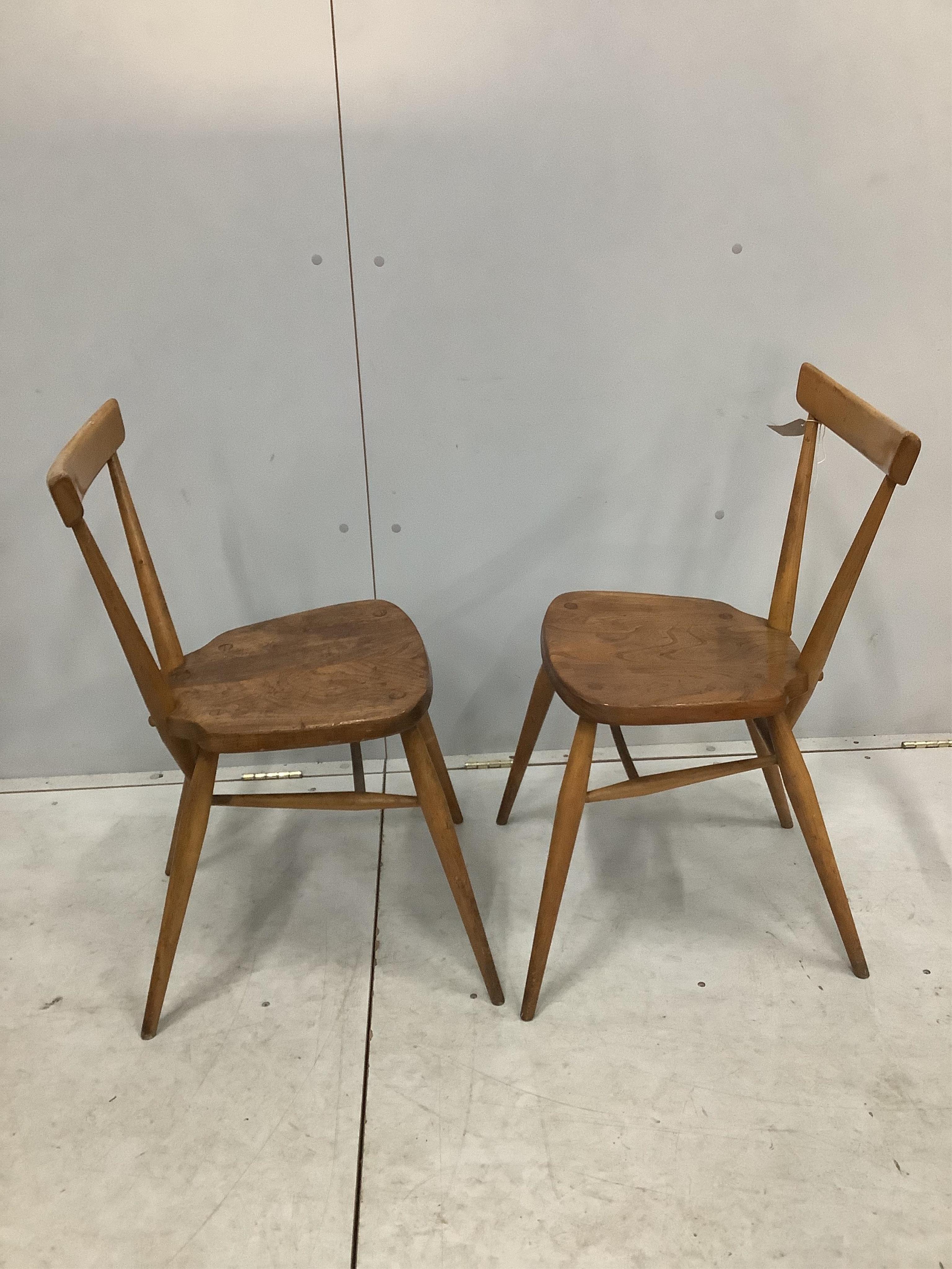 A pair of mid century Ercol elm and beech stacking chairs, width 39cm, depth 35cm, height 76cm. Condition - fair